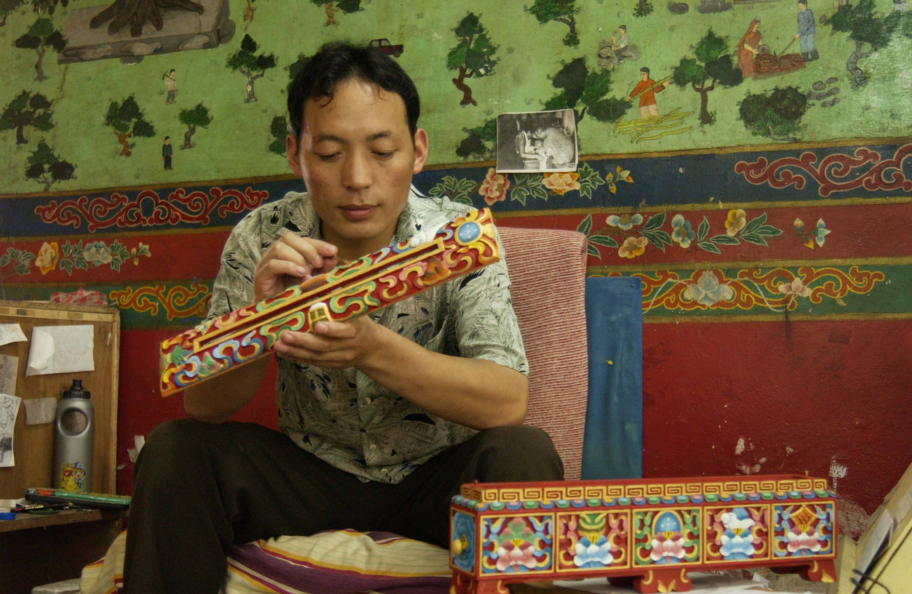 Norbulingka craftsman painting carved wood